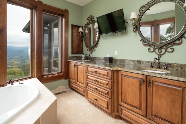 bathroom featuring vanity and tiled bath