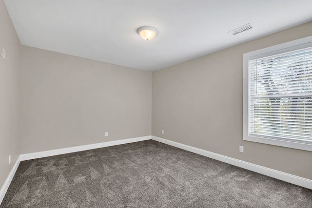 unfurnished room with dark colored carpet