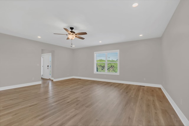 empty room with ceiling fan and light hardwood / wood-style flooring