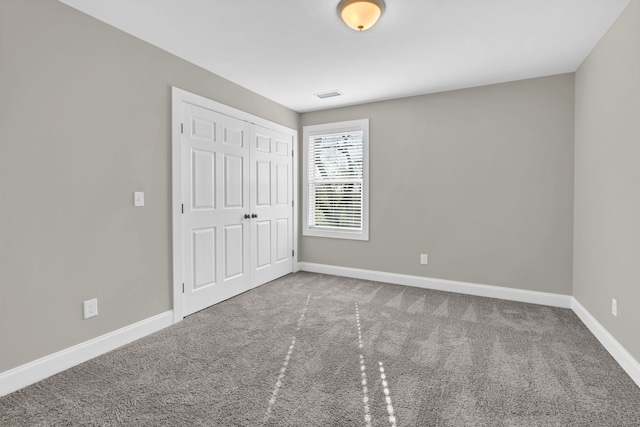 unfurnished bedroom with carpet floors and a closet