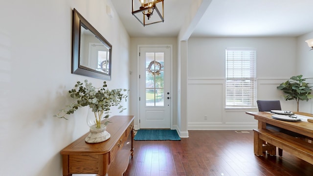 foyer featuring a chandelier and dark wood-type flooring