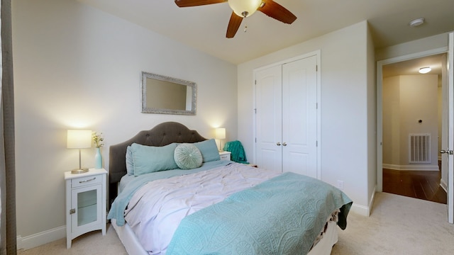 bedroom featuring a closet, ceiling fan, and light carpet