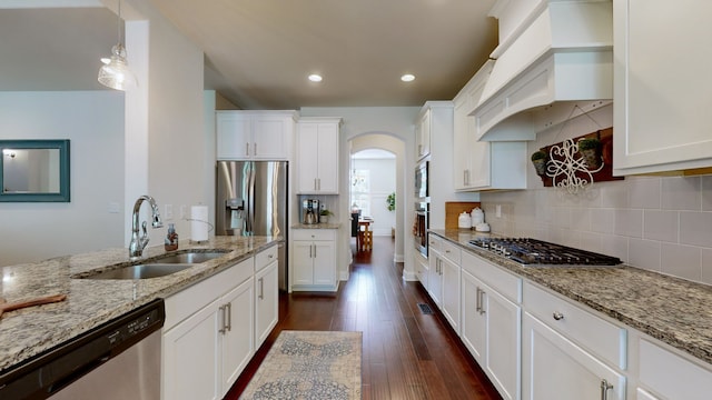 kitchen with sink, white cabinetry, decorative light fixtures, and stainless steel appliances