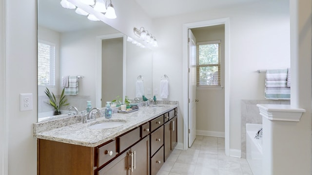 bathroom with vanity, tile patterned floors, a healthy amount of sunlight, and a washtub