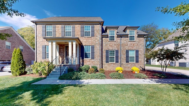 view of front facade with a front yard and central AC unit