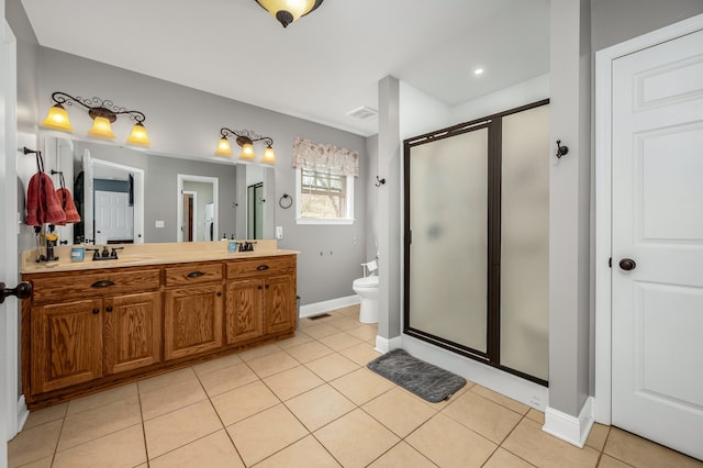 bathroom with tile patterned flooring, a shower with shower door, vanity, and toilet