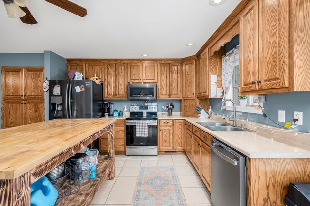 kitchen featuring appliances with stainless steel finishes, ceiling fan, sink, and light tile patterned flooring