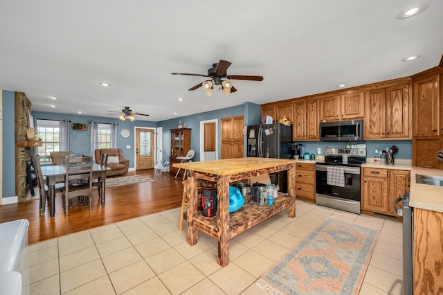 kitchen featuring wood counters, ceiling fan, stainless steel appliances, and light hardwood / wood-style flooring