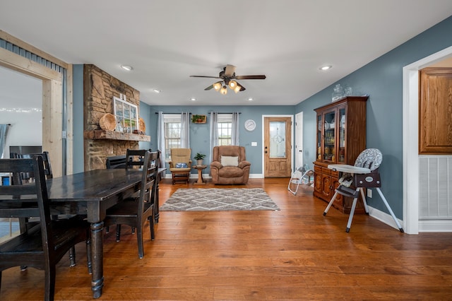 dining area featuring hardwood / wood-style flooring, a fireplace, and ceiling fan