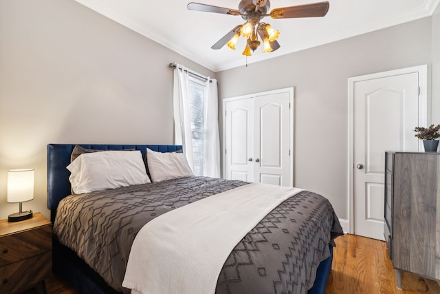 bedroom with ceiling fan, a closet, ornamental molding, and light hardwood / wood-style flooring