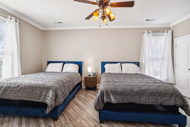 bedroom with ceiling fan, crown molding, and wood-type flooring