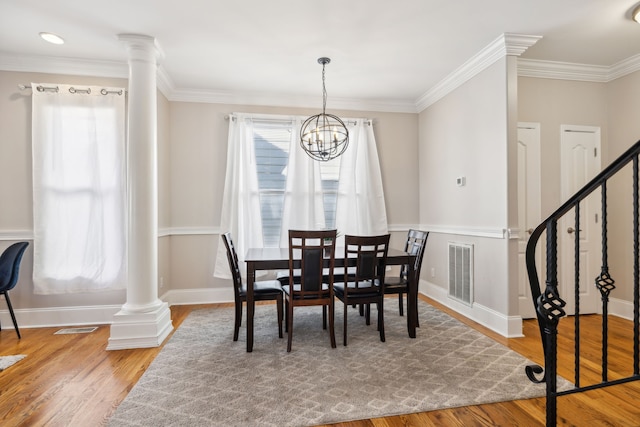 dining room featuring an inviting chandelier, ornamental molding, and hardwood / wood-style flooring