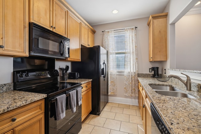 kitchen with light stone counters, sink, light tile patterned floors, and black appliances