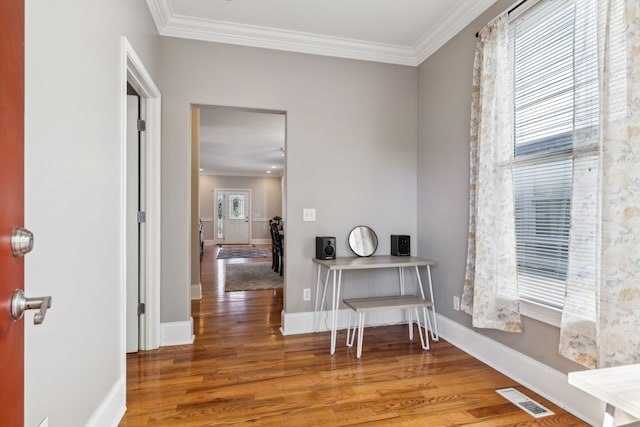 office space featuring plenty of natural light, wood-type flooring, and ornamental molding