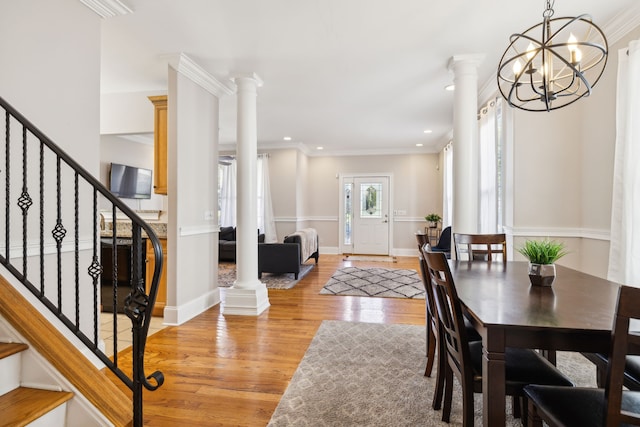 dining space featuring light wood-type flooring, ornamental molding, and a chandelier