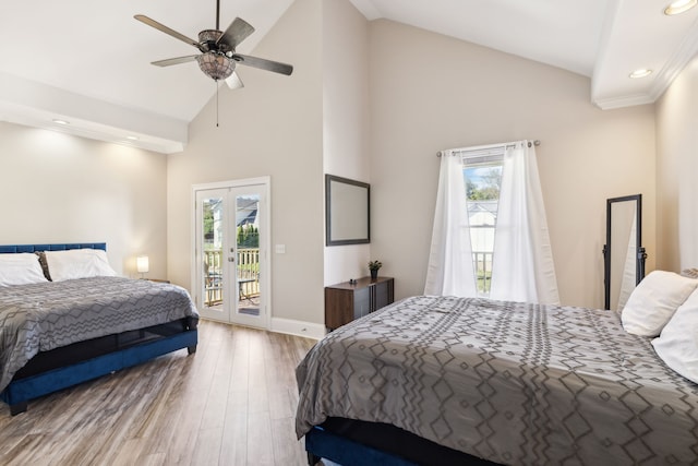 bedroom featuring multiple windows, light hardwood / wood-style flooring, high vaulted ceiling, and access to exterior