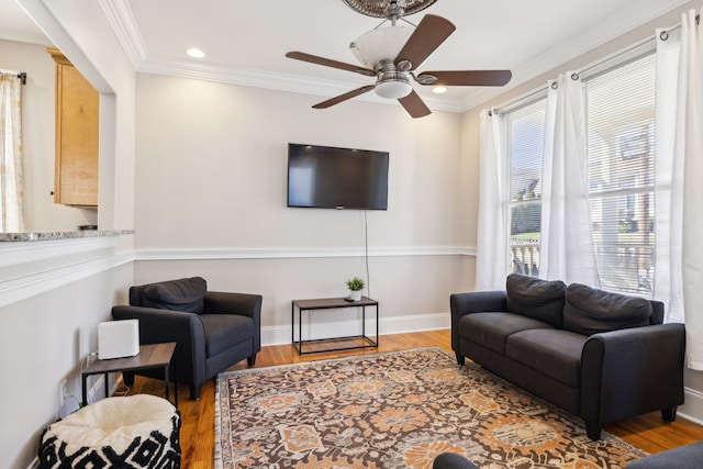 living room featuring light hardwood / wood-style flooring, ceiling fan, and crown molding