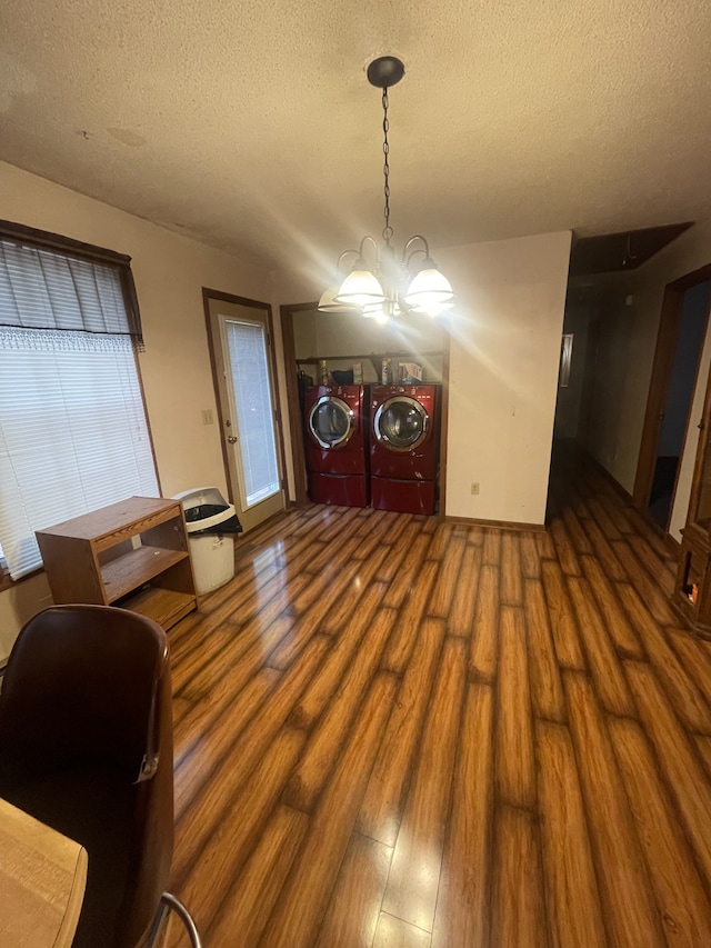 interior space with dark wood-type flooring, washer and dryer, a textured ceiling, and a notable chandelier