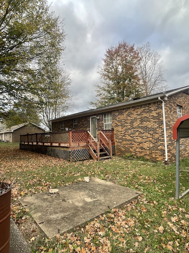 rear view of property with a lawn, a patio area, and a wooden deck