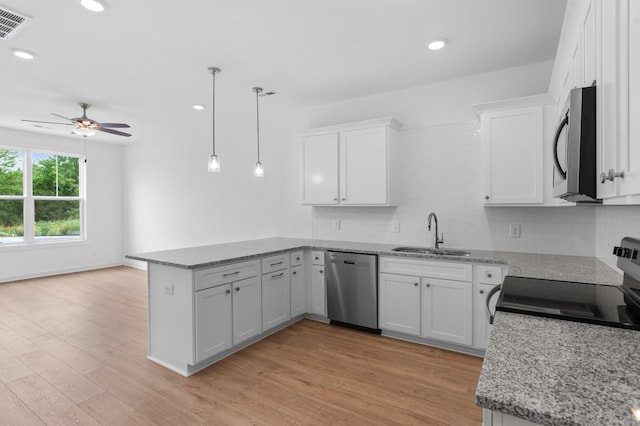 kitchen featuring light hardwood / wood-style floors, sink, stainless steel appliances, kitchen peninsula, and white cabinets