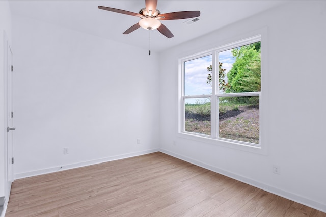 spare room featuring ceiling fan, light hardwood / wood-style flooring, and a healthy amount of sunlight