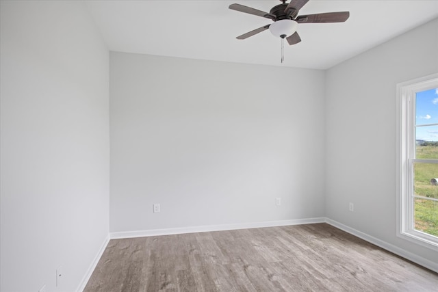 spare room with ceiling fan, light wood-type flooring, and a wealth of natural light