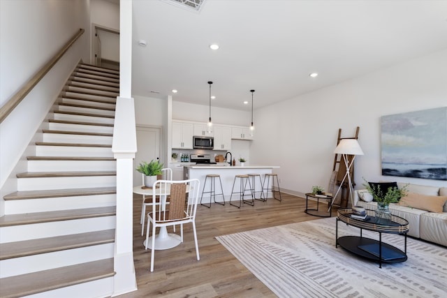 living room with sink and light hardwood / wood-style floors