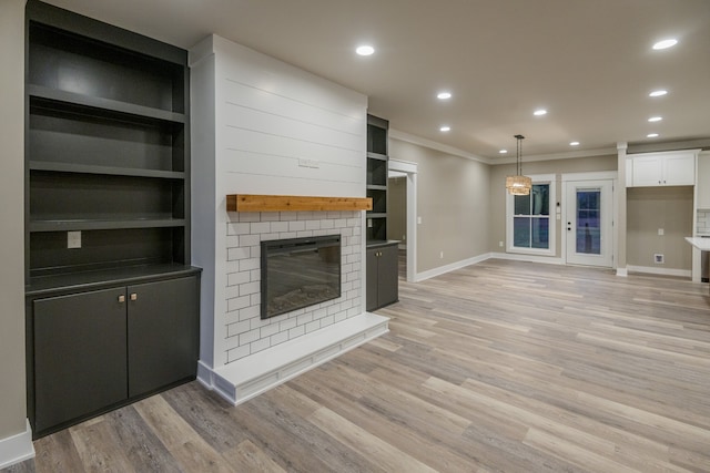 unfurnished living room with a fireplace, light hardwood / wood-style flooring, and crown molding