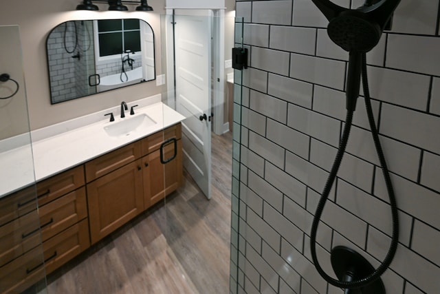 bathroom featuring vanity, tile walls, hardwood / wood-style flooring, and a shower with door