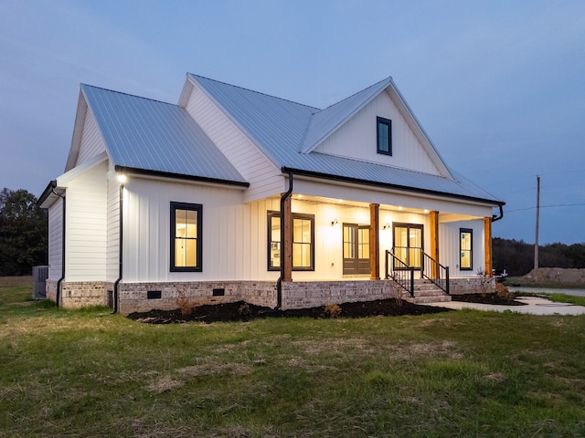 view of front facade with central air condition unit, a porch, and a yard