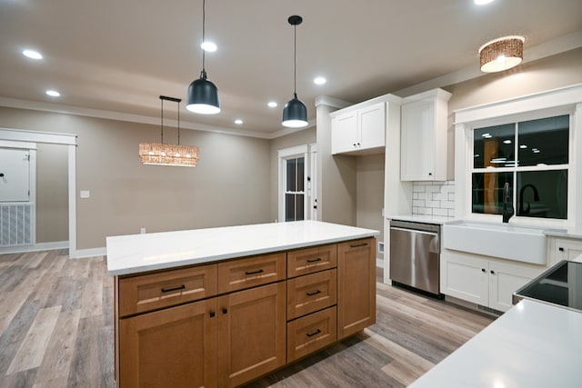 kitchen featuring tasteful backsplash, stainless steel dishwasher, light hardwood / wood-style flooring, white cabinets, and pendant lighting