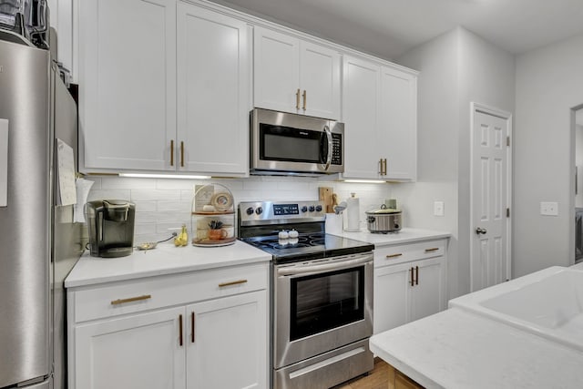 kitchen featuring tasteful backsplash, sink, white cabinets, and stainless steel appliances