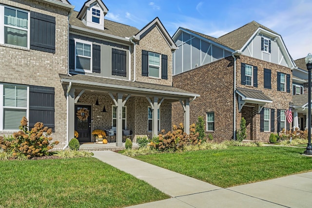 multi unit property featuring a porch and a front lawn