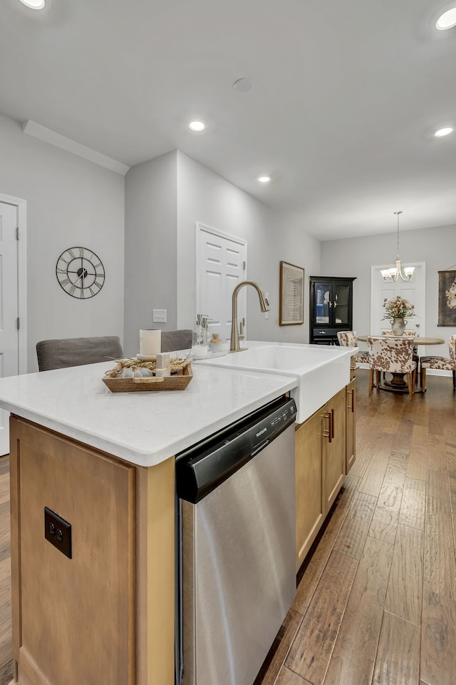 kitchen featuring a kitchen island with sink, pendant lighting, light hardwood / wood-style flooring, a notable chandelier, and dishwasher