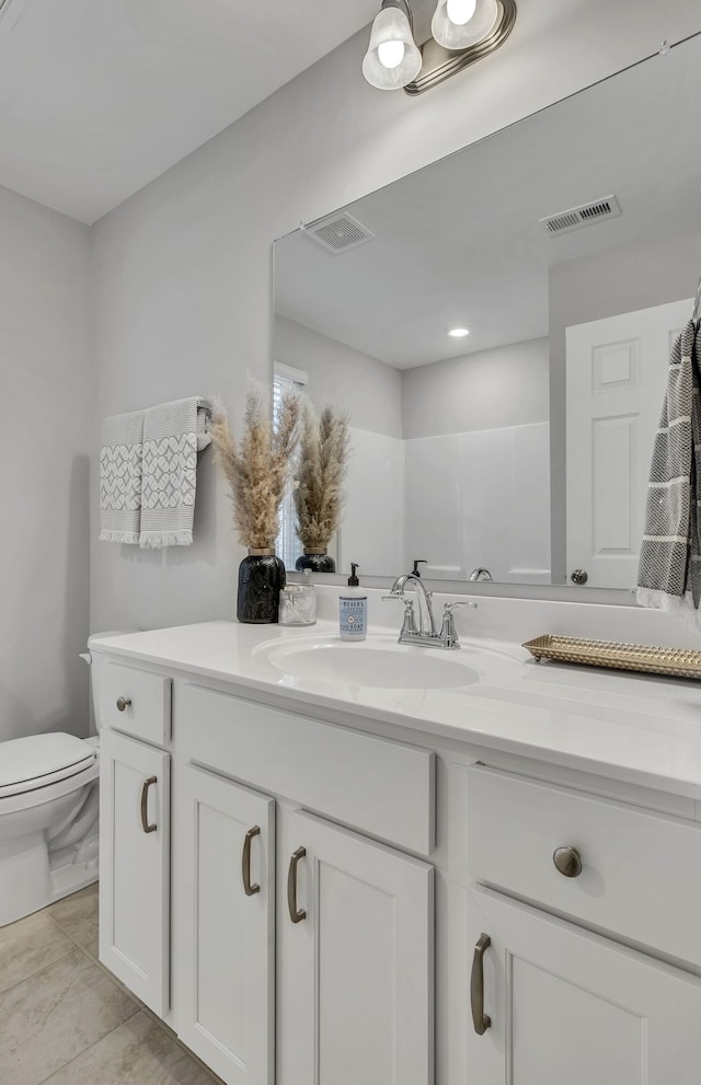 bathroom with walk in shower, tile patterned flooring, vanity, and toilet