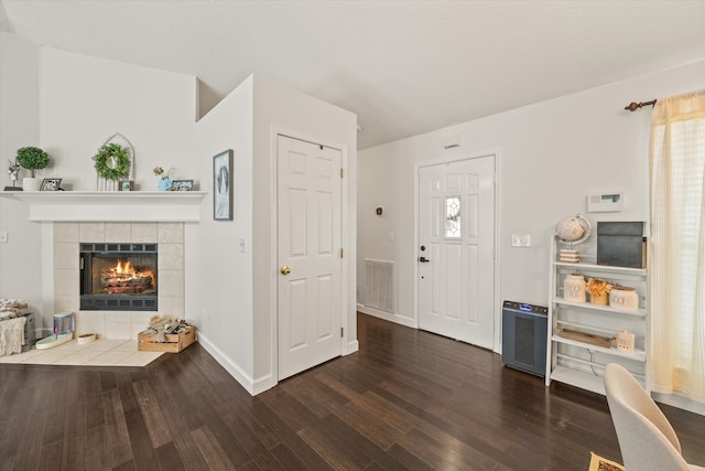 entryway with a fireplace, plenty of natural light, and dark hardwood / wood-style flooring