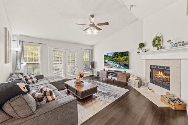 living room with ceiling fan, a fireplace, vaulted ceiling, and hardwood / wood-style floors