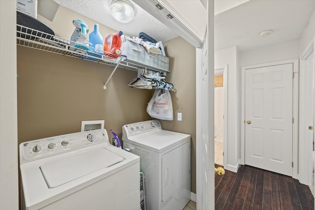 clothes washing area with separate washer and dryer, dark hardwood / wood-style floors, and a textured ceiling