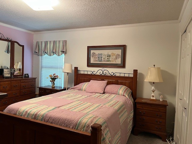 bedroom with a closet, carpet, ornamental molding, and a textured ceiling