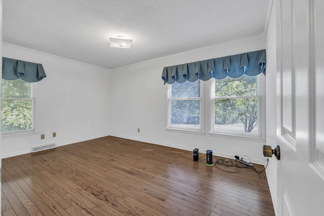 empty room featuring ornamental molding, hardwood / wood-style floors, and a textured ceiling