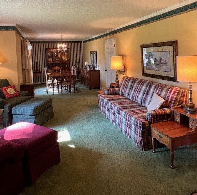 living room featuring carpet floors, an inviting chandelier, ornamental molding, and a textured ceiling