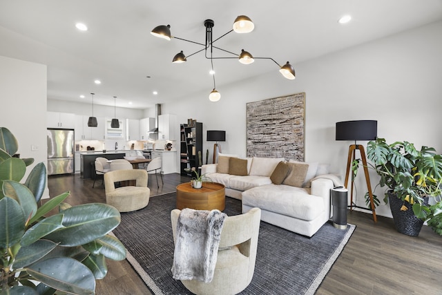 living room with an inviting chandelier and dark hardwood / wood-style flooring