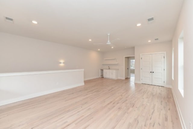 unfurnished living room featuring light wood-type flooring and ceiling fan