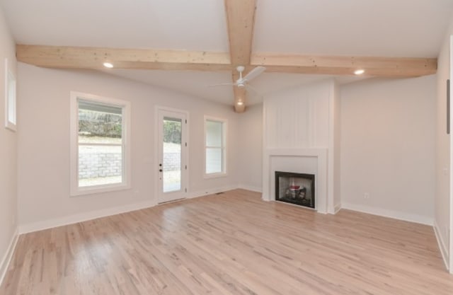 unfurnished living room with beam ceiling, light wood-type flooring, ceiling fan, and a large fireplace