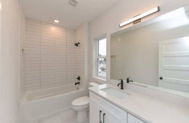 full bathroom with vanity, tiled shower / bath combo, and toilet