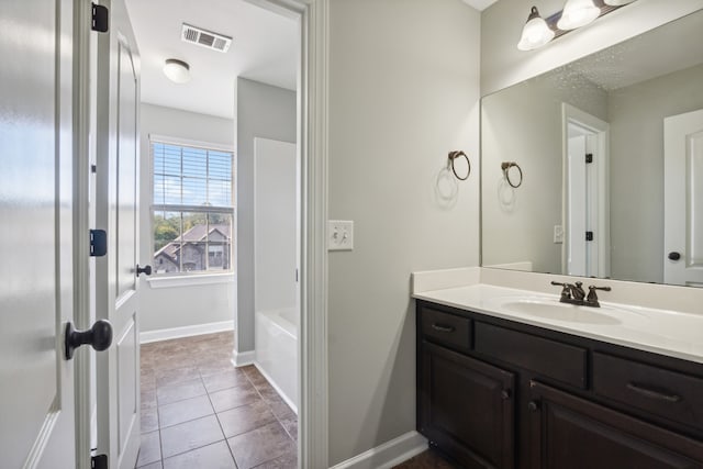 bathroom with vanity, a bath, and tile patterned flooring