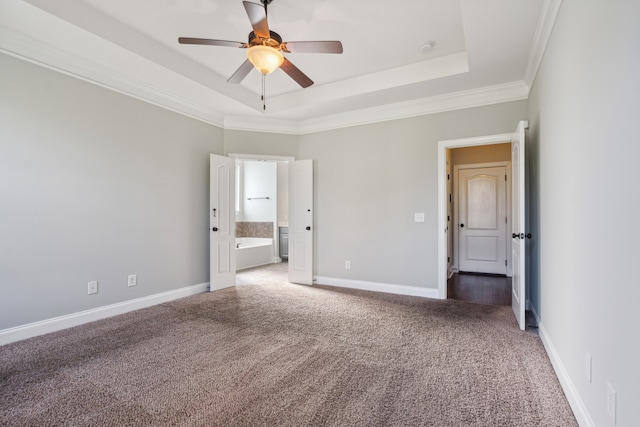 unfurnished bedroom with ornamental molding, carpet flooring, a tray ceiling, and ceiling fan