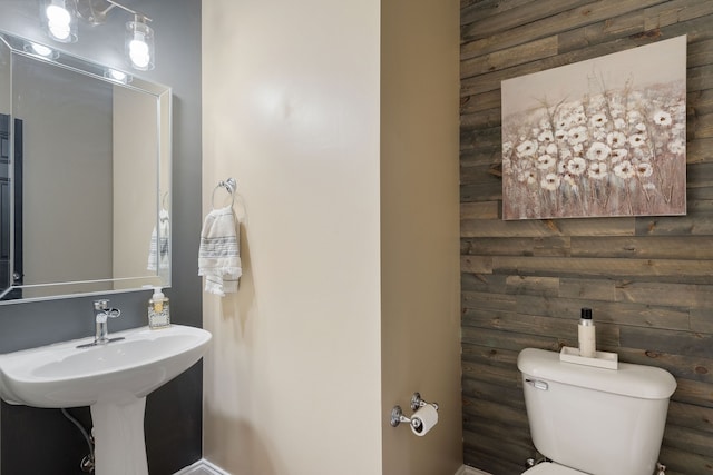 bathroom with wooden walls and toilet