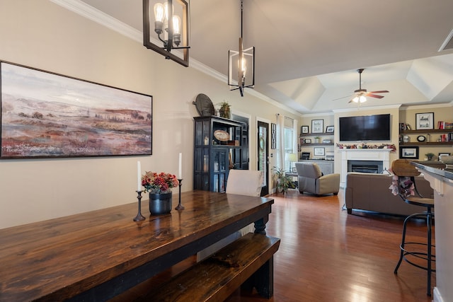 dining room featuring ceiling fan with notable chandelier, dark hardwood / wood-style floors, a tray ceiling, and crown molding