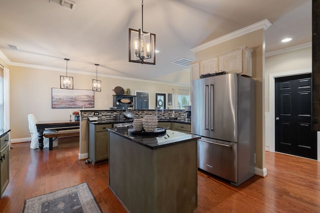 kitchen with high end fridge, dark hardwood / wood-style flooring, kitchen peninsula, pendant lighting, and backsplash